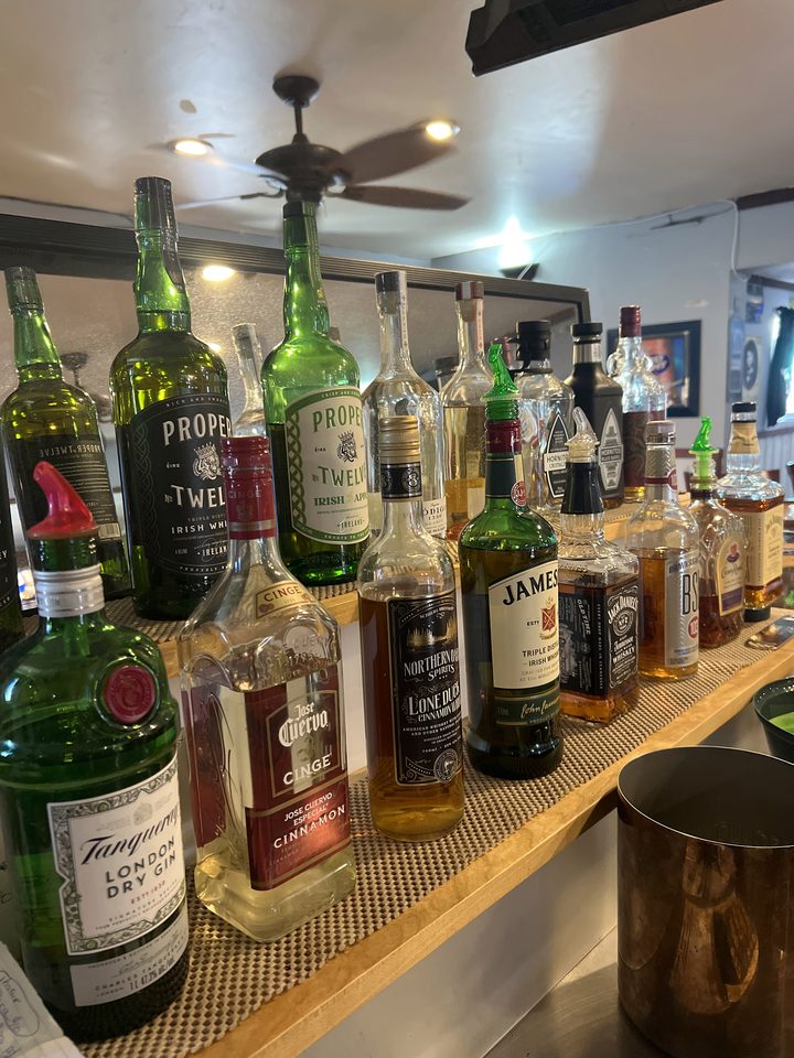 Whiskey, gin and liqueur bottles on the back bar at The Root Cellar