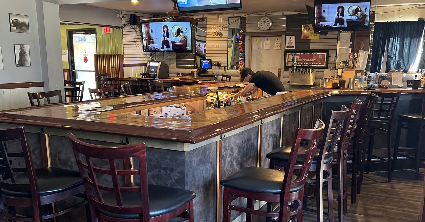 Inside The Root Cellar in Black Creek, WI: the wood bar top, bar stools and TVs