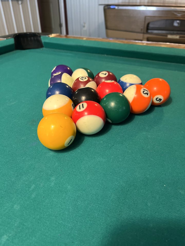 Racked pool balls on the green felt at The Root Cellar